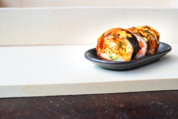 Korean food, gimbap or kimbap in a plate on a wooden background.