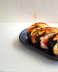 Korean food, gimbap or kimbap in a plate on a wooden background.