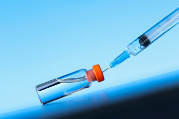 Growth vaccination with coronavirus vaccine and syringe against blue background. Healthcare And Medical concept.