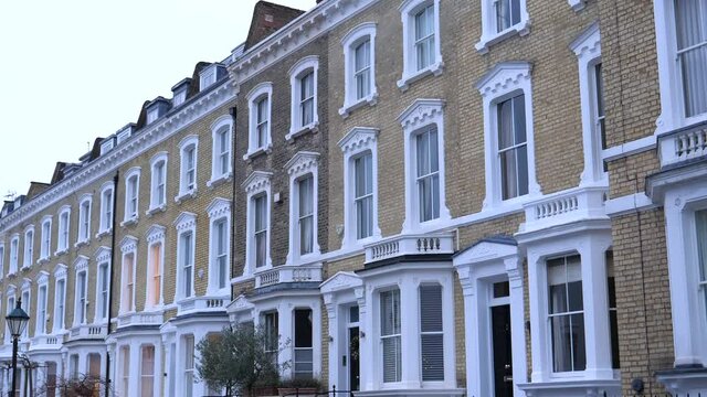 Panning shot of nice yellow brick house terrace in London Chelsea district.