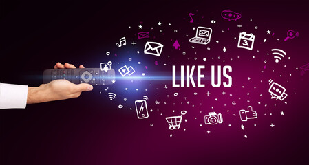 hand holding wireless peripheral with LIKE US inscription, social media concept
