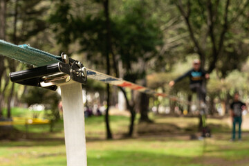 Hombre desenfocado haciendo equilibrio sobre una correa de nylon practicando Slacklining