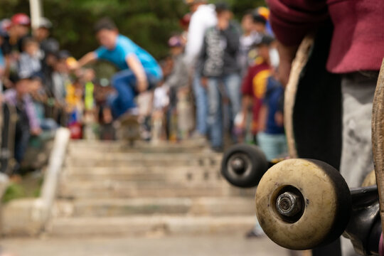 Ni&ntilde;o en patineta desenfocado saltando las escaleras, rueda de otra patineta enfocada
