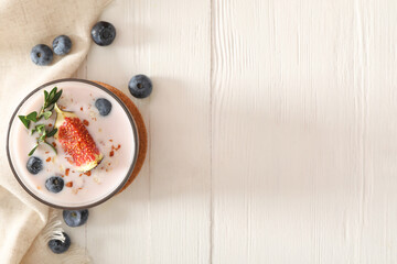 Delicious fig smoothie in glass on white wooden table, flat lay. Space for text