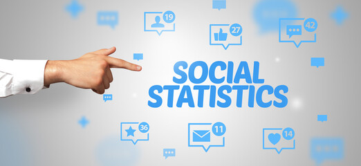 Close-Up of cropped hand pointing at SOCIAL STATISTICS inscription, social networking concept