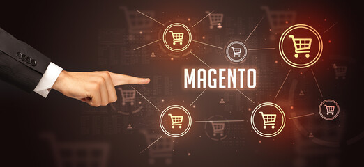 Close-Up of cropped hand pointing at MAGENTO inscription, online shopping concept