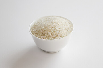 rice grains in a bowl isolated on white background.