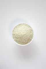 rice grains in a bowl isolated on white background.