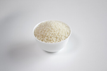 rice grains in a bowl isolated on white background.