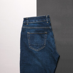 Dark men's jeans on a black and white background.