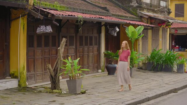 A young woman tourist visits an ancient town of Hoi An in the central part of Vietnam. Travel to Vietnam concept