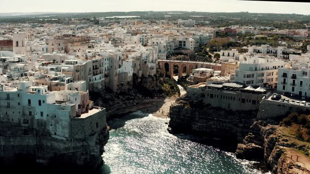 Aerial view on an ancient city coast with beach in Italy.
