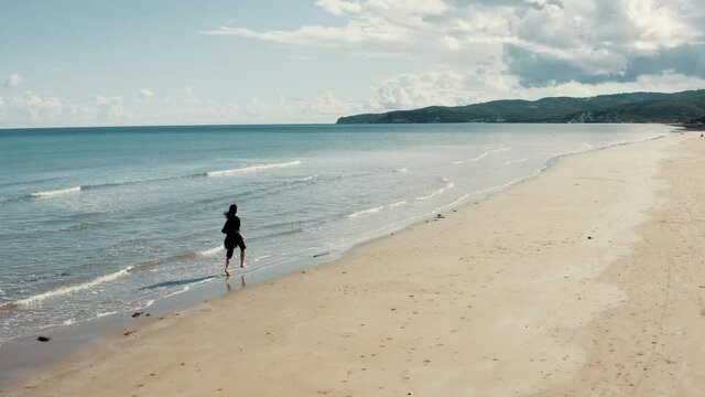 Aerial view on girl running on the beach.