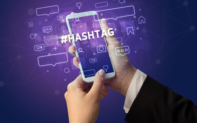 Female hand typing on smartphone with #HASHTAG inscription, social media concept