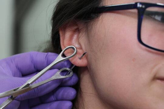 Perforaci&oacute;n piercing en oreja l&oacute;bulo arete en estudio de tatuajes