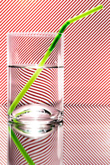 refraction of light by a wine glass on a red and white striped background. Abstract glass art. Valentines Day Concept