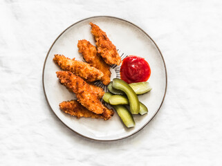 Chicken fingers, cornichons and ketchup - delicious tapas, appetizers, snack on the light background, top view