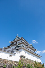 Wakayama, Wakayama Prefecture / Japan, October 15 2020: Low angle view of Wakayama castle with a nearly cloudless blue sky on an early autumn day.
