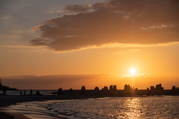 Naklejka premium Cloudy sunset with silhouette of a rocky shore at Shirahama Beach in Wakayama Prefecture, Japan