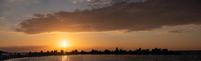 Panorama of cloudy sunset with silhouette of a rocky shore at Shirahama Beach in Wakayama Prefecture, Japan