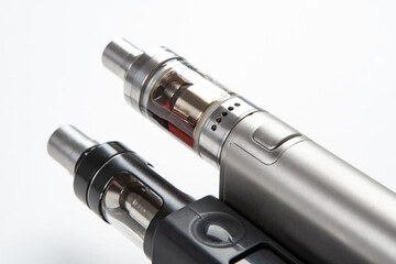 Two Electronic Cigarette close-up. Fragment of Electronic Cigarette on a white background. Vaping cigarettes. Devices for smoking steam. Cigarettes are modern. Concept devices from vape shop