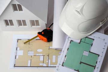 Architectural blueprints and construction helmet on desktop. Builder desktop top view. Concept -...