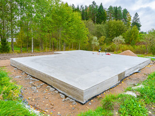 Concrete foundation next to trees. Construction near forest. Construction site with foundation....