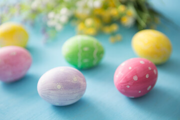 Easter eggs decoration with flowers on blue wooden table