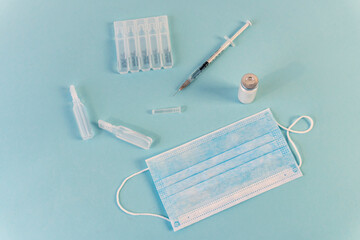 Flat Lay for medical theme and vaccinations from COVID-19. Medicine, vaccine, syringe, mask.