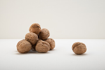 Unpeeled walnuts in a shell on a light background