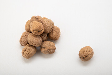 Unpeeled walnuts in a shell on a light background