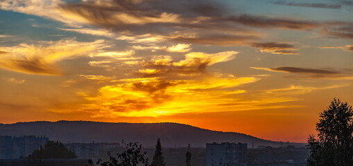 Sunset over the city and mountains in summer