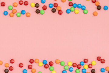 empty copy space for text in the middle, top view of Colorful chocolate coated candy on pink background with valentines. Valentines day concept festive food gifts