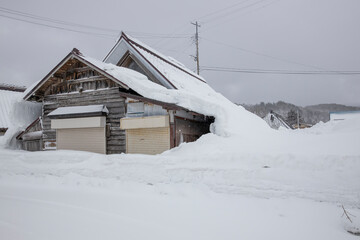 屋根雪の重みでで倒壊しそうな家 © kelly marken