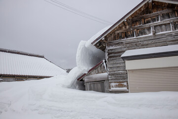 屋根雪の重みでで倒壊しそうな家