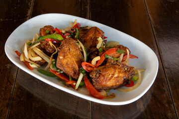 Chili chicken wings on a white plate