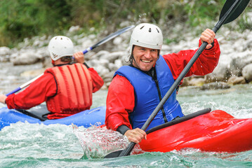 Gutgelaunt unterwegs im Kajak auf einem Gebirgsfluss