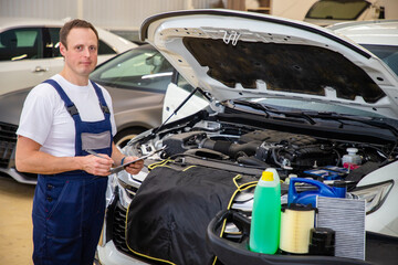 An auto mechanic does maintenance to the car.