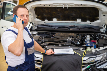 An auto mechanic does maintenance to the car.