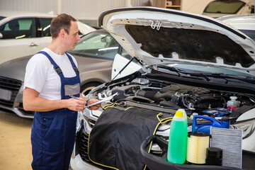 An auto mechanic does maintenance to the car.