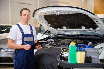 An auto mechanic does maintenance to the car.