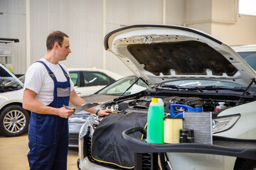 An auto mechanic does maintenance to the car.
