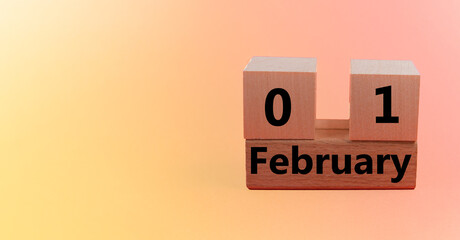 Wooden block calendar with date 01 on yellow pink gradient holiday background with copy space and space for your text