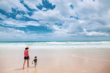Mother and son walking on the beach