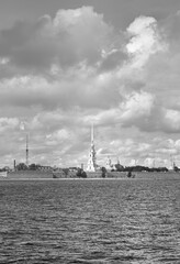 Peter and Paul fortress on the Neva. The spire of the Cathedral of the XVIII century against a cloudy sky, waves on the river, stone bastions