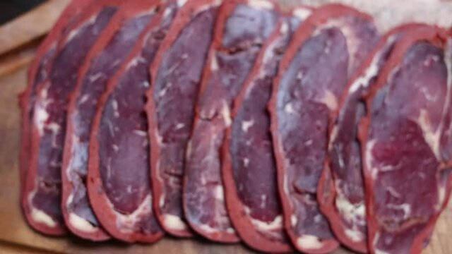 beef bacon sliced ​​on wood board. blurry background. traditional turkish food pastirma