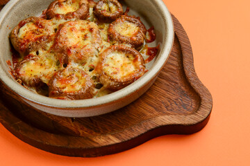Stuffed mushrooms with parmesan cheese inside. Delicious baked mushrooms served in a ceramic bowl.
