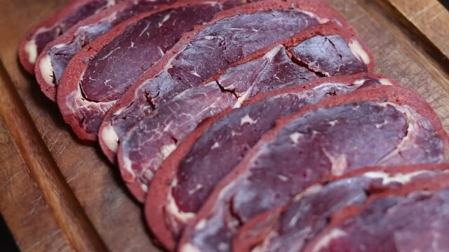 beef bacon sliced ​​on wood board. blurry background. traditional turkish food pastirma