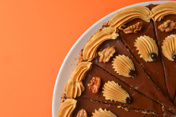 Chocolate cake with icing on top and with nuts over colorful background