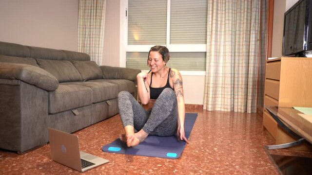 Woman prepares to start online yoga class in the living room